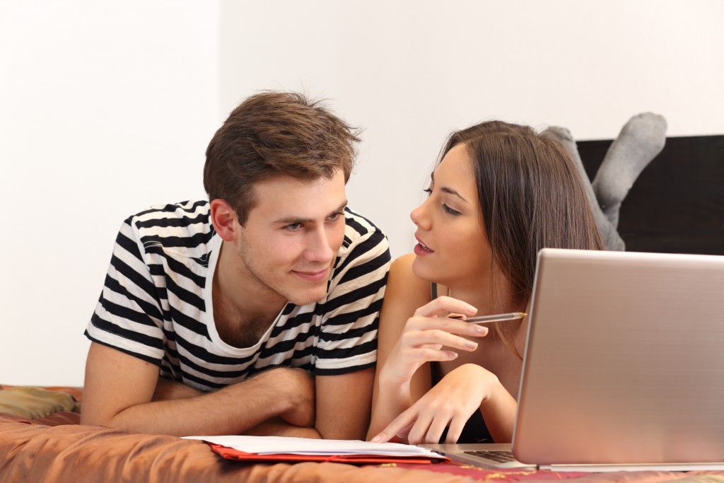 Couple-lying-on-bed-with-laptop-in-front-of-them-1024x683.jpg
