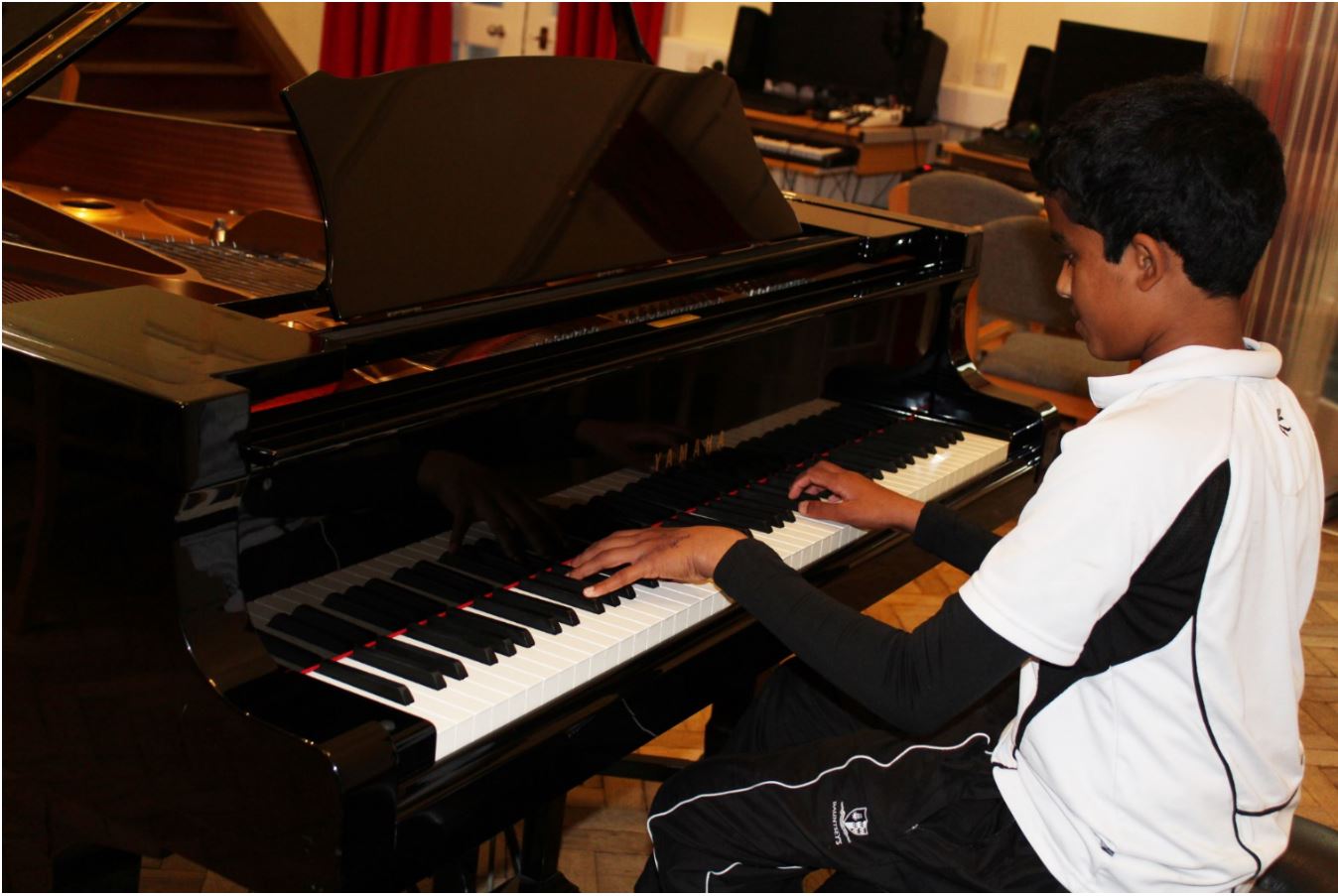 A school pupil sits down to play the piano